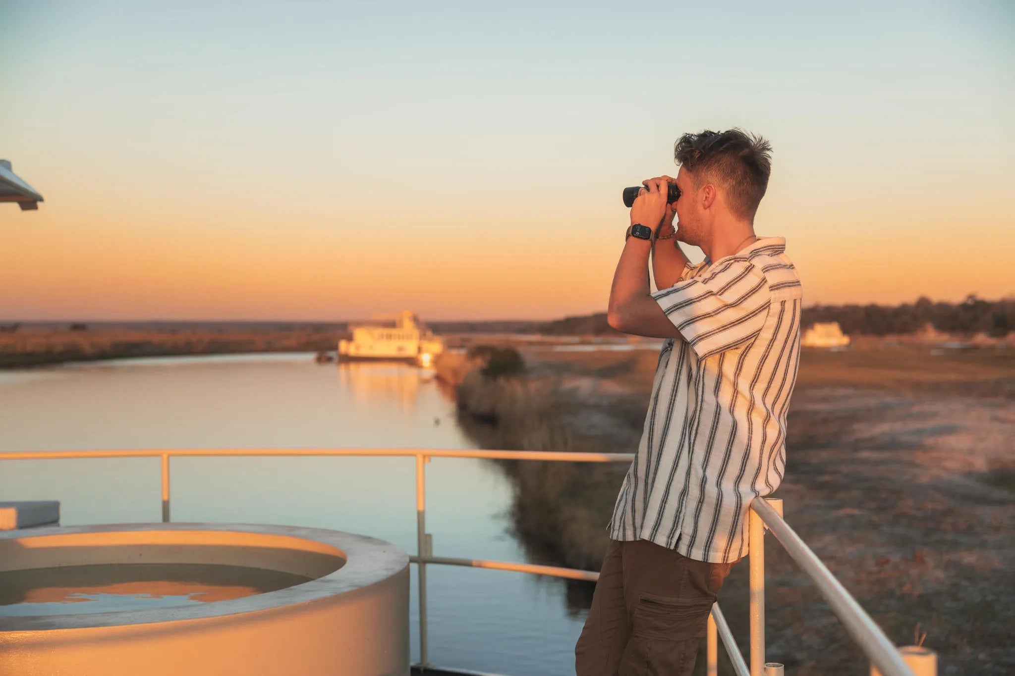Chobe Princess Guest looking through binoculars at Chobe Princess By Mantis, Chobe River Front Namibia, Namibia.