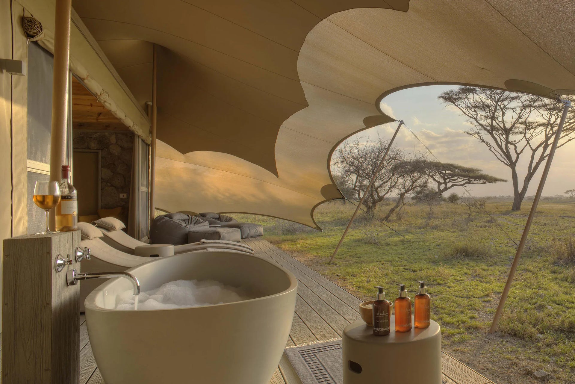 Namiri Plains - Tent Deck with Bath, Sunbeds and Cushion Corner at Namiri Plains Camp, Eastern Serengeti, Tanzania.