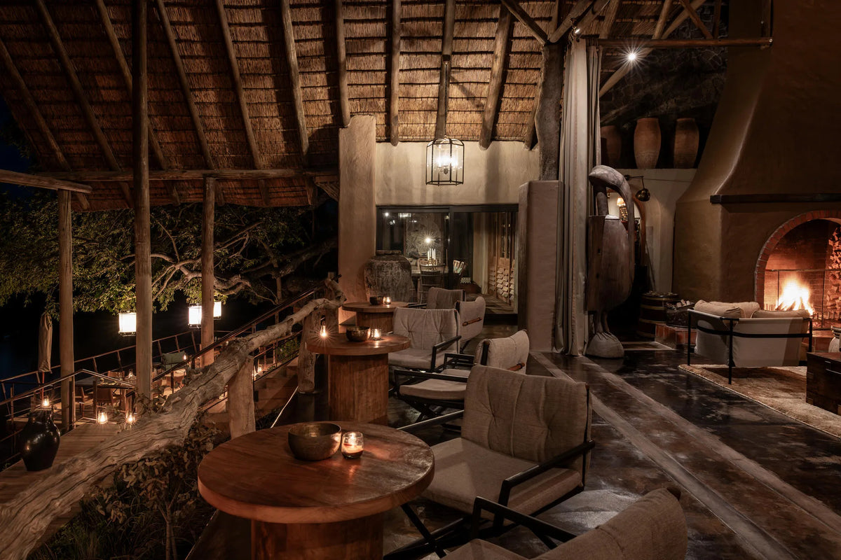 Main Lounge & Fireplace at night at Singita Ebony Lodge, Sabi Sand Nature Reserve, South Africa.