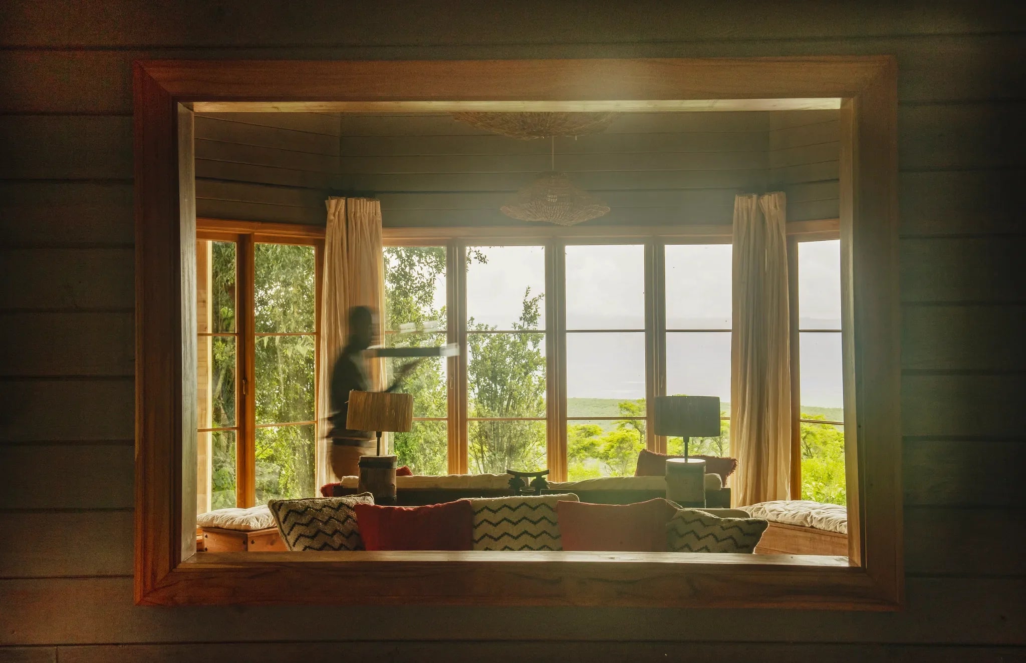 A waiter walks past a window in the Entamanu mess at Entamanu Ngorongoro, Ngorongoro Crater, Tanzania.