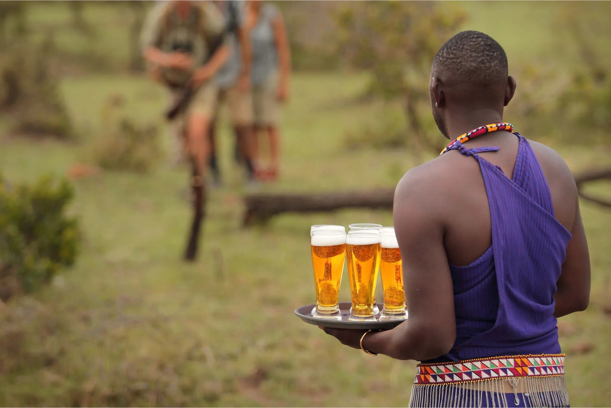Kokoko - Friendly Staff Welcoming Guests With a Cold Drink at Kokoko Camp, Ruaha National Park, Tanzania.