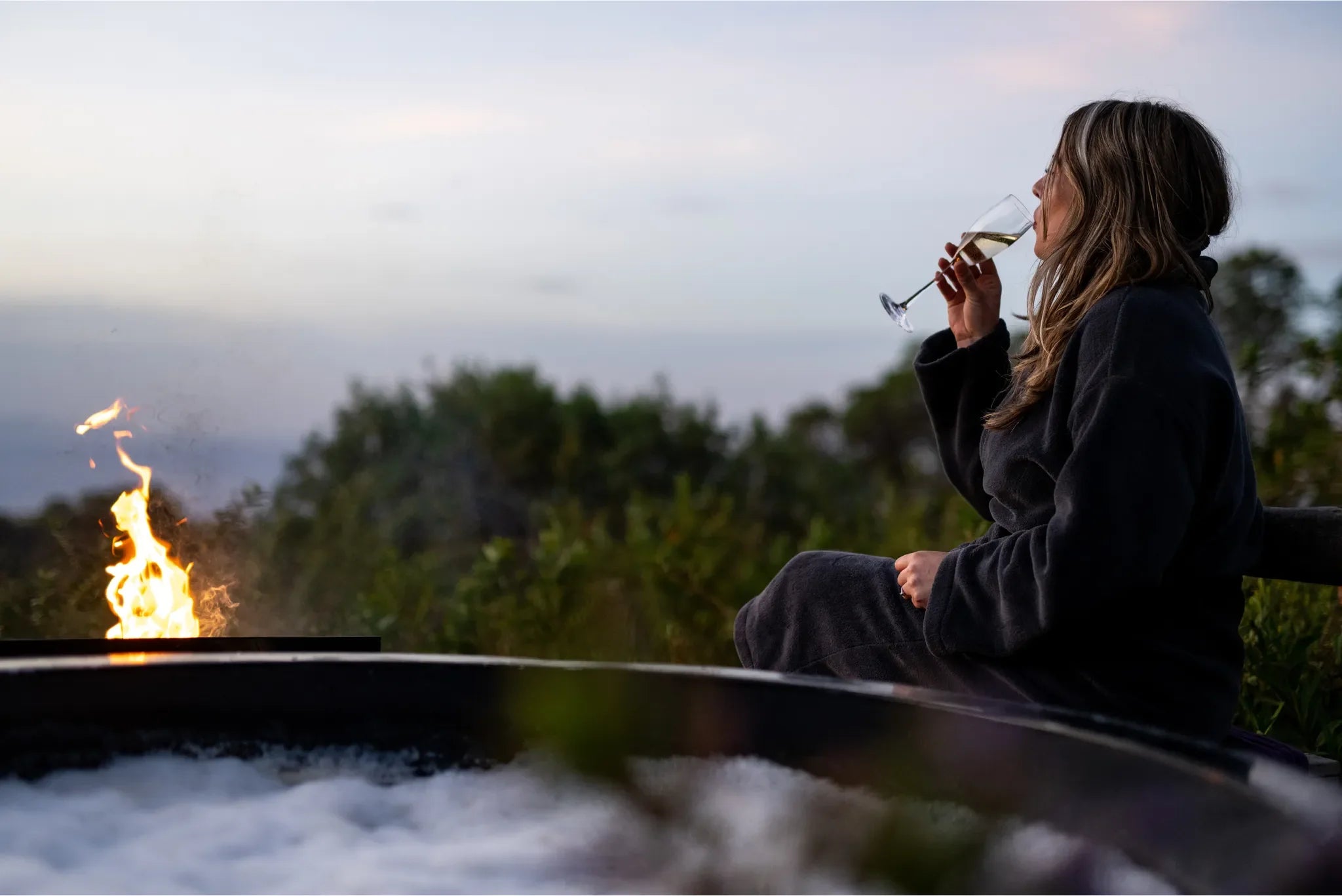 The Highlands - Guest Enjoying a Glass of Champagne at the Hot Tub at The Highlands, Ngorongoro Crater, Tanzania.