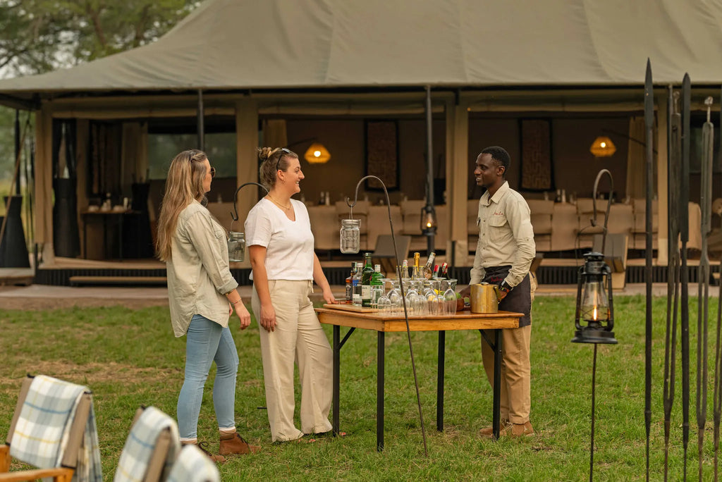 Ubuntu Camp - Guests chatting to waiter at Ubuntu Migration Camp - South (Dec - Mar), Southern Serengeti, Tanzania.