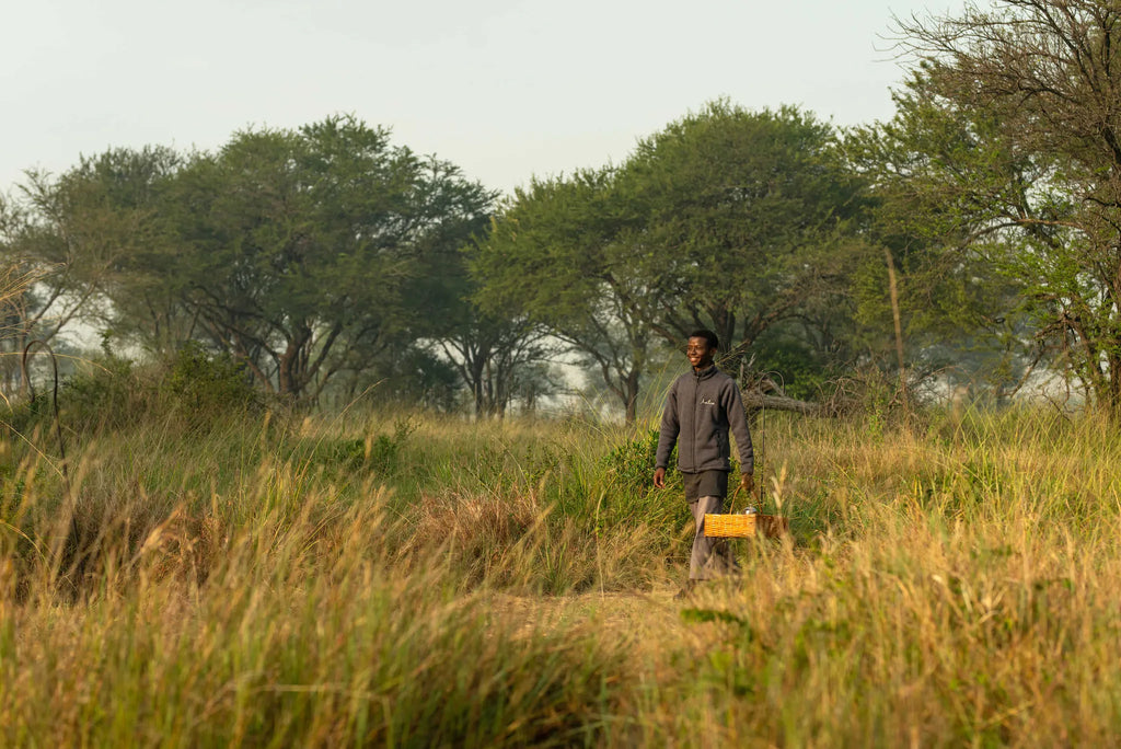 Ubuntu Camp - Staff member carrying a basket at Ubuntu Migration Camp - South (Dec - Mar), Southern Serengeti, Tanzania.