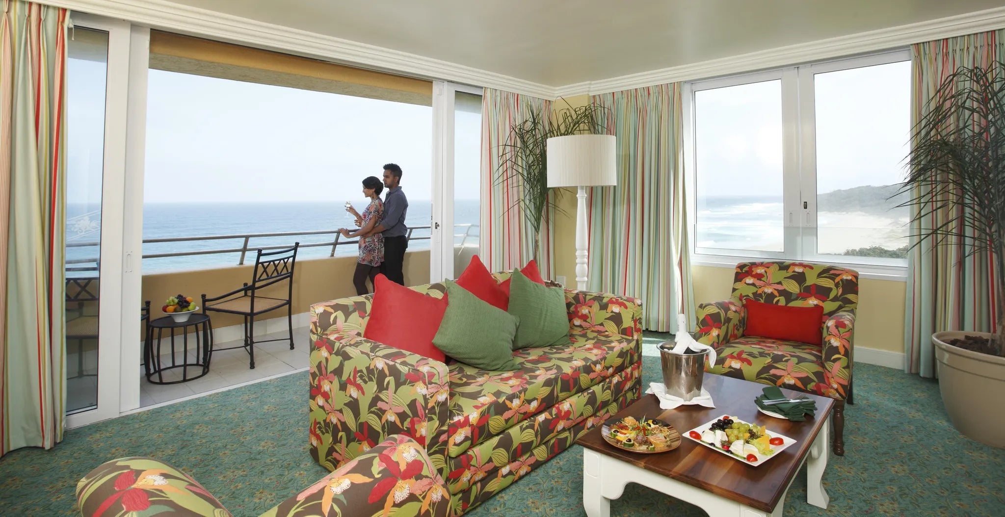 Wild Coast Sun Suite- Presidential Suite-lounge-with couple on the balcony at Wild Coast Sun, The Wild Coast, South Africa.